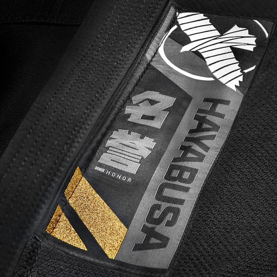 Hayabusa Ascend svart – stoff, sømmer og gullfarget broderi